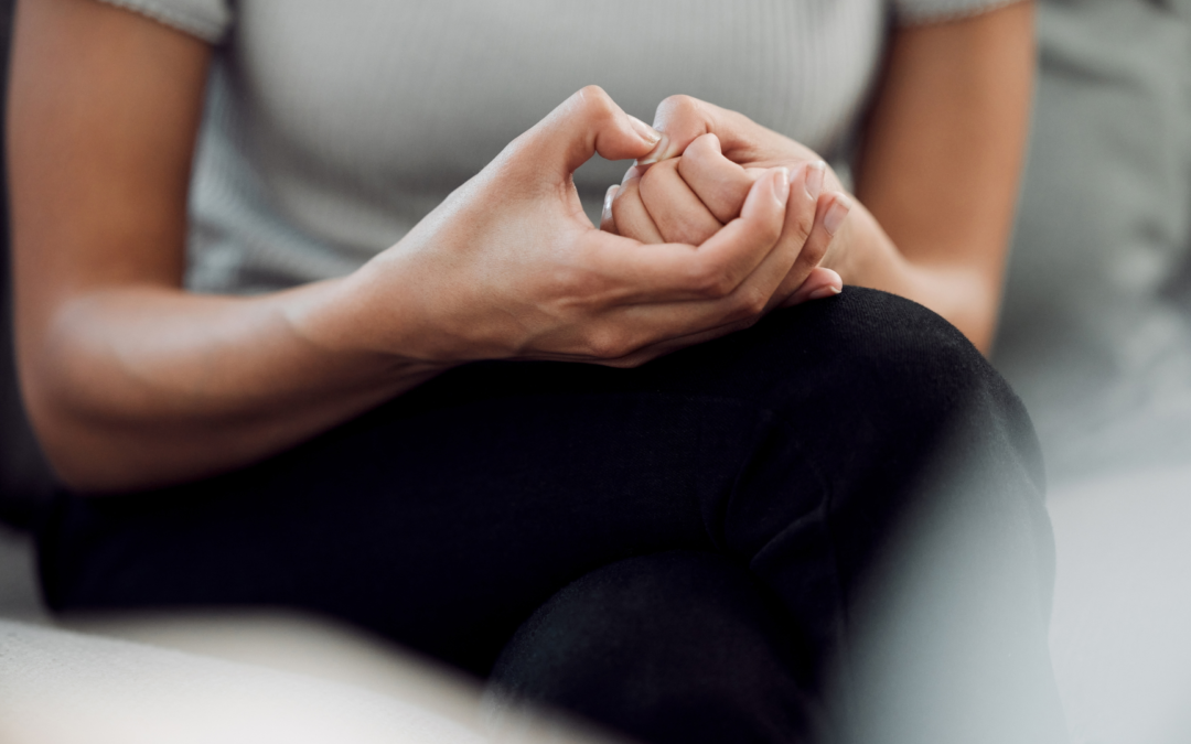 A woman sitting in a peaceful setting with closed eyes, taking a deep breath, symbolizing the practice of mindfulness and anxiety management.